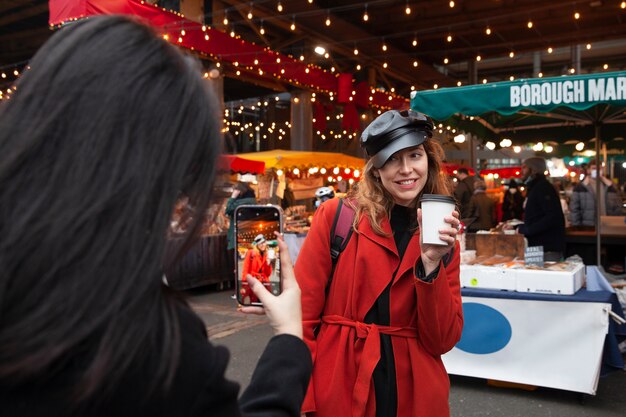 Frau fotografiert einen weiblichen Influencer auf dem Markt