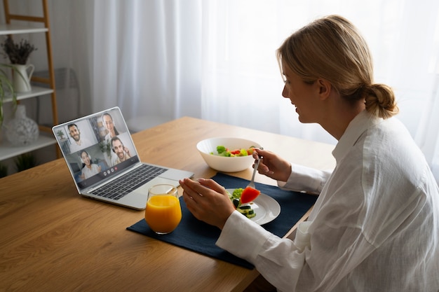 Kostenloses Foto frau führt beim essen einen videoanruf