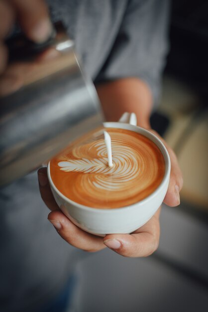 Frau gießt Kaffeesahne