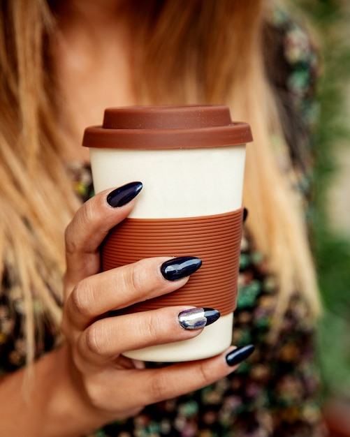 Frau hält eine Tasse Kaffee