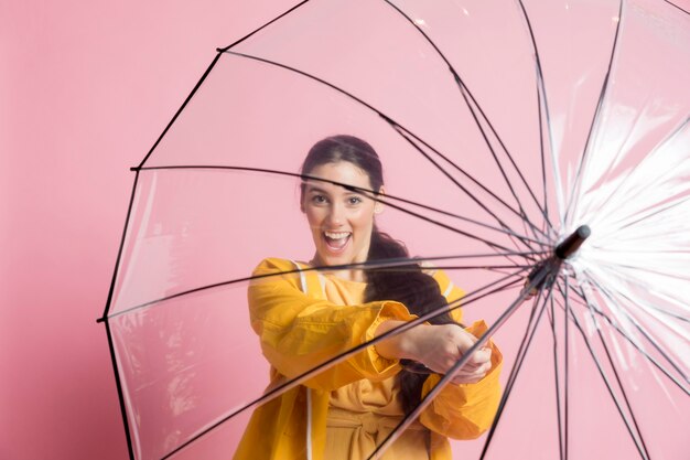 Frau hält einen geöffneten Regenschirm vor sich