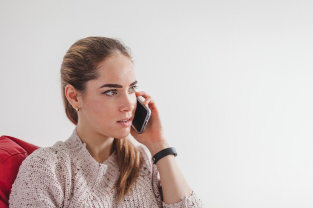 Frau hält Smartphone am Ohr