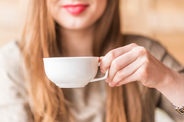 Frau halten einen weißen Becher