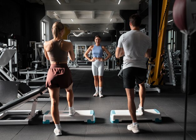 Frau hilft Mann im Fitnessstudio