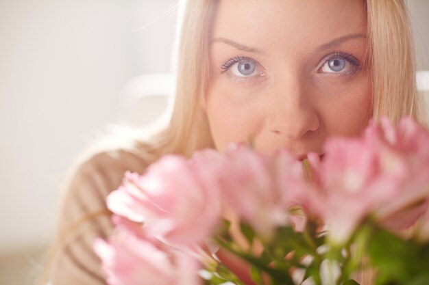 Frau hinter einem Blumenstrauß