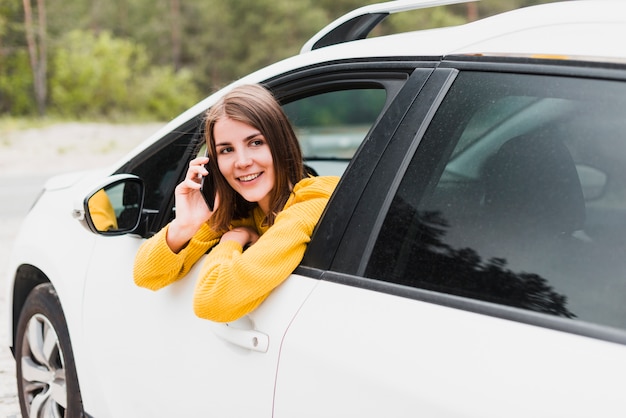 Frau im Auto am Telefon sprechen