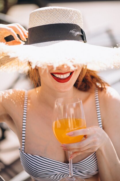 Frau im Badeanzug auf einem trinkenden Saft der Ferien