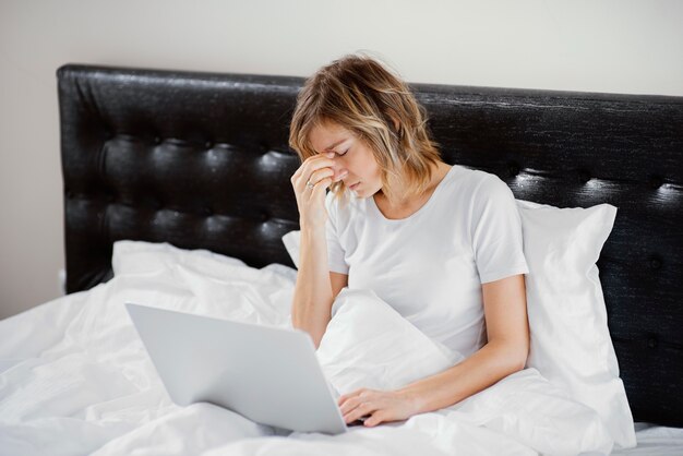 Frau im Bett mit Laptop