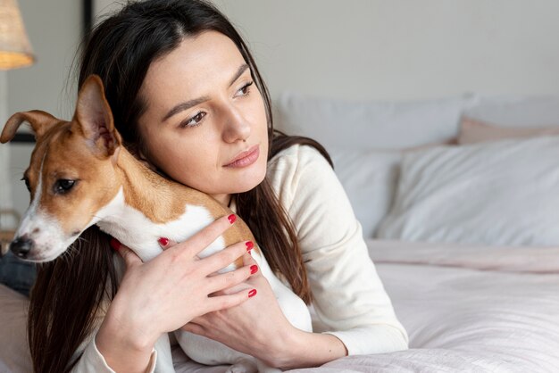Frau im Bett posiert mit ihrem Hund