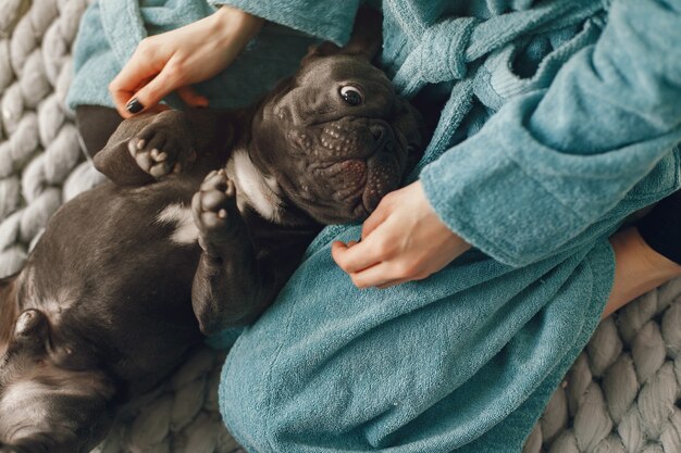 Frau im blauen Bademantel mit schwarzer Bulldogge