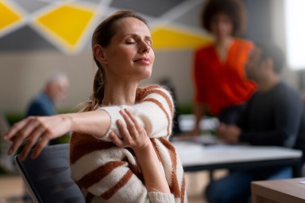 Frau im Büro, die sich während eines Arbeitstages dehnt