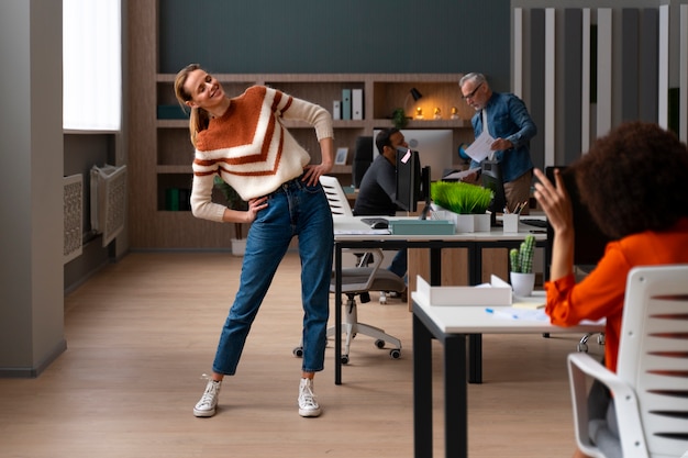 Frau im Büro, die sich während eines Arbeitstages dehnt