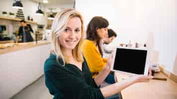 Kostenloses Foto frau im café, das tablettenschirm zeigt