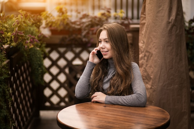 Frau im Café mit Telefon