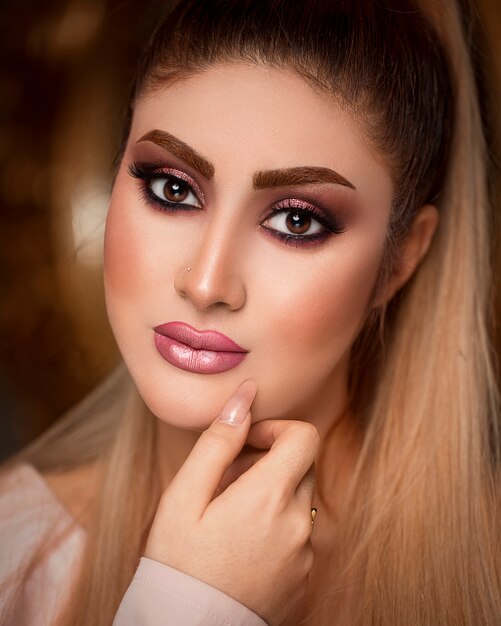 Frau im eleganten sonnengebräunten Make-up mit blonden Haaren