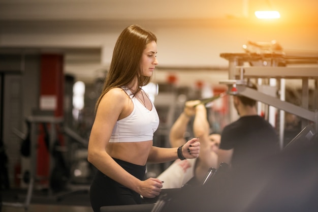 Frau im Fitnessstudio auf einer laufenden Maschine