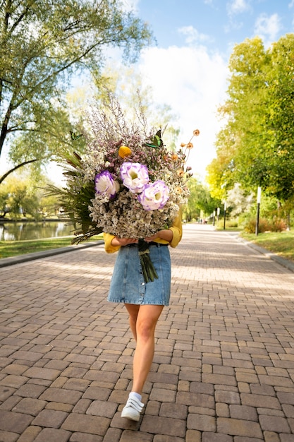 Kostenloses Foto frau im frühjahr mit blumenstrauß