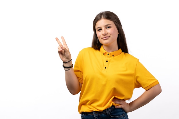 Frau im gelben Hemd und in den blauen Jeans, die auf der weißen Hintergrundfrauenmodellkleidung posieren und lächeln