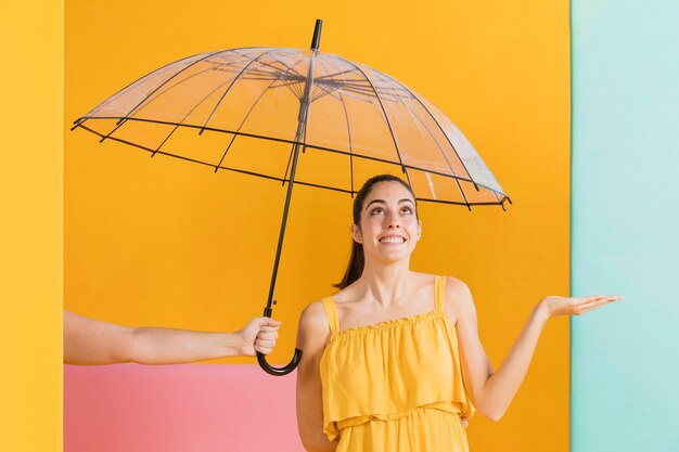 Frau im gelben Kleid mit einem Regenschirm