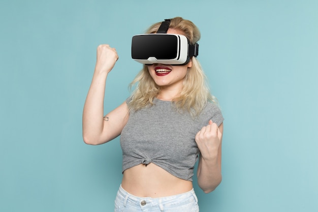 Frau im grauen Hemd und in den hellen blauen Jeans, die vr spielen