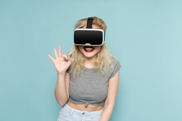 Frau im grauen Hemd und in den hellen blauen Jeans, die vr spielen