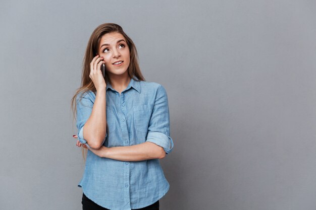 Frau im Hemd, die am Telefon spricht