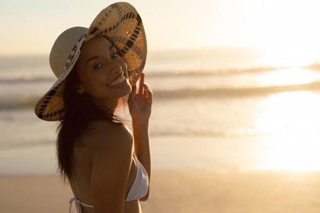 Frau im Hut stehen am Strand