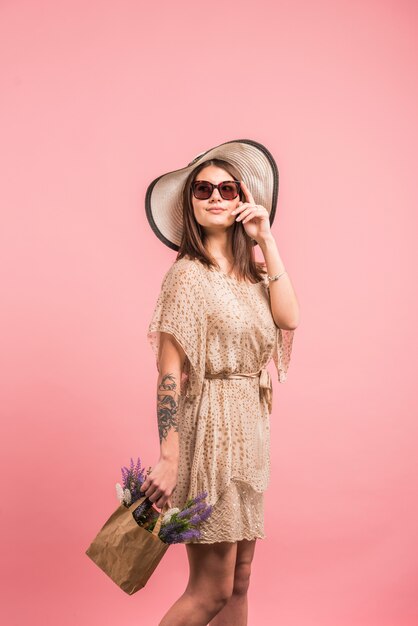 Frau im Kleid mit Blumen in der Tasche