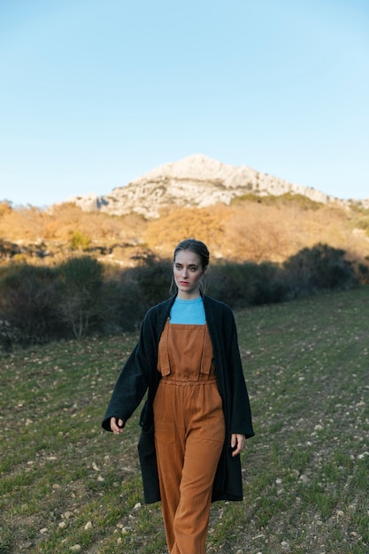 Kostenloses Foto frau im overall, der nahe bäumen geht