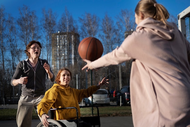 Frau im Rollstuhl, die Basketball-Seitenansicht spielt
