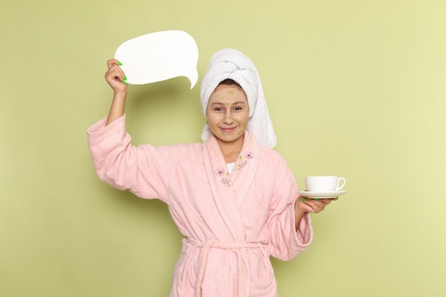 Frau im rosa Bademantel, der Kaffeetasse hält