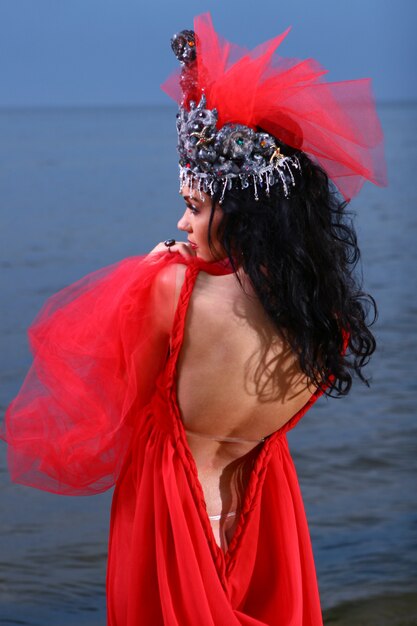 Frau im roten Kleid am Strand