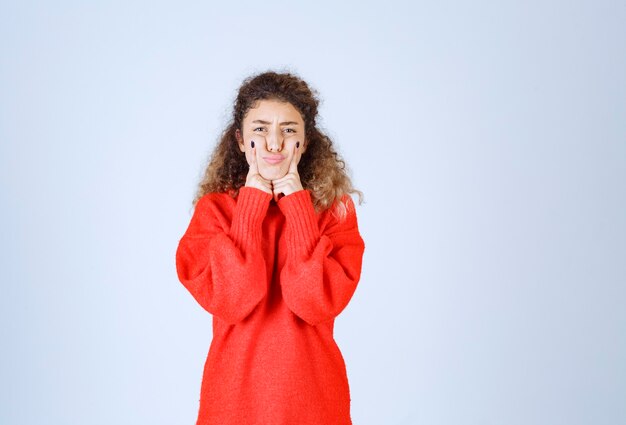 Frau im roten Sweatshirt bedeutet ihr Lächeln.