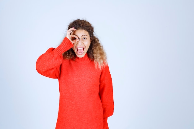 Kostenloses Foto frau im roten sweatshirt, das genusszeichen zeigt.