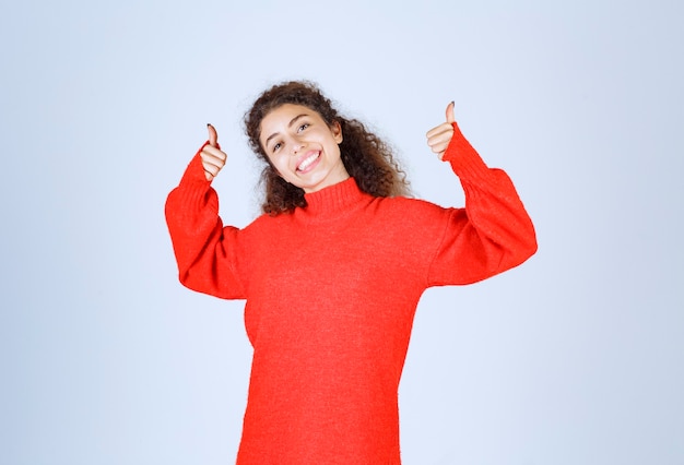 Frau im roten Sweatshirt, das Genusszeichen zeigt.