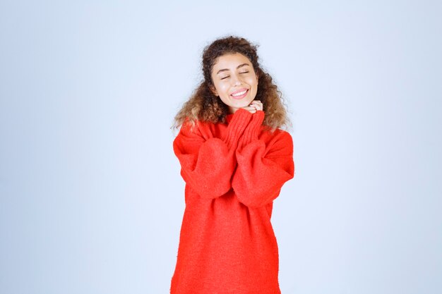 Frau im roten Sweatshirt, die fröhliche und positive Posen gibt.