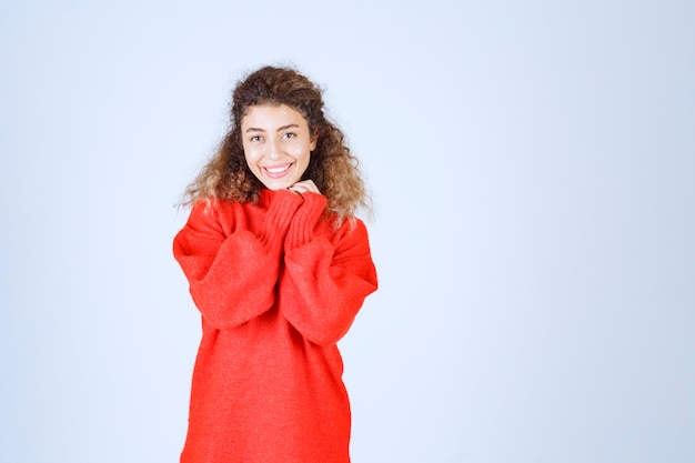 Frau im roten Sweatshirt, die fröhliche und positive Posen gibt.