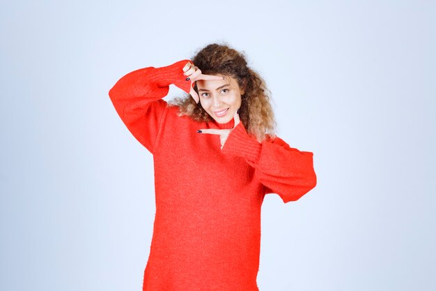 Frau im roten Sweatshirt mit Foto-Capture-Zeichen.