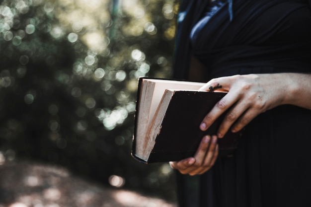 Frau im schwarzen haltenen Buch im Holz