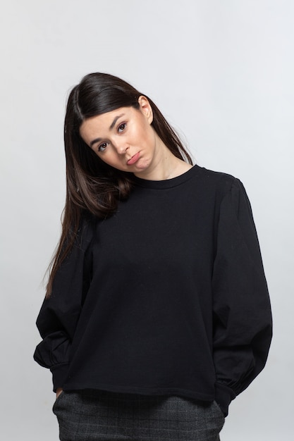 Frau im schwarzen Pullover zeigt Traurigkeit