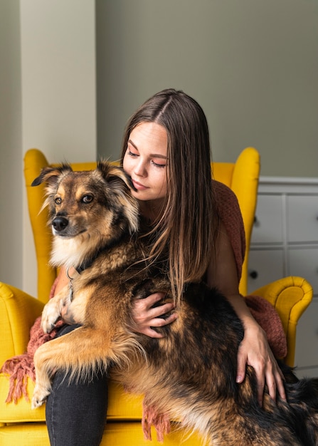 Frau im Sessel mit ihrem Hund während der Pandemie