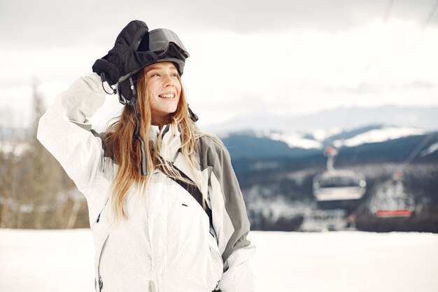 Frau im Snowboardanzug. Sportlerin auf einem Berg mit einem Snowboard in den Händen am Horizont. Konzept zum Sport