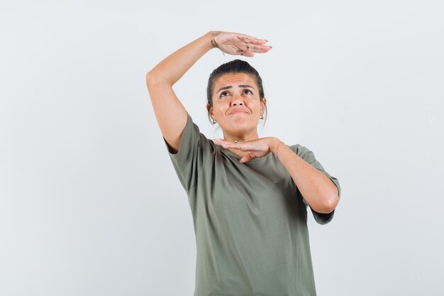 Frau im T-Shirt, das traditionelle Tanzgeste zeigt und niedlich schaut