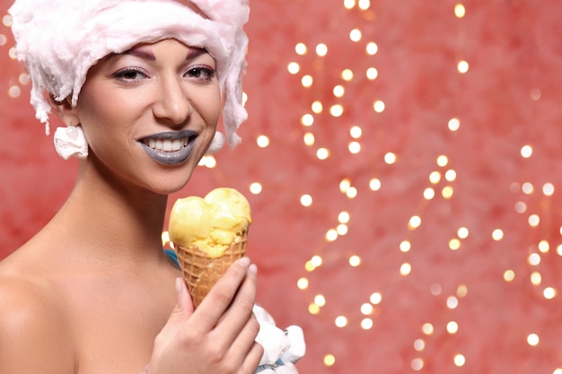 Frau im ungewöhnlichen Kleid aus Marshmallow und Perücke aus Zuckerwatte