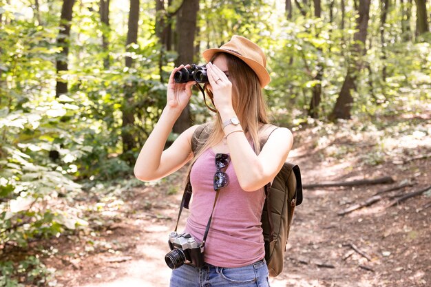 Frau im Wald mit Fernglas