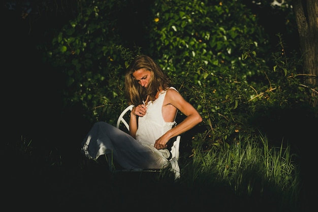 Frau im weißen Kleid im Garten