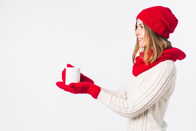 Frau in der hellen Strickjacke, die Schale hält