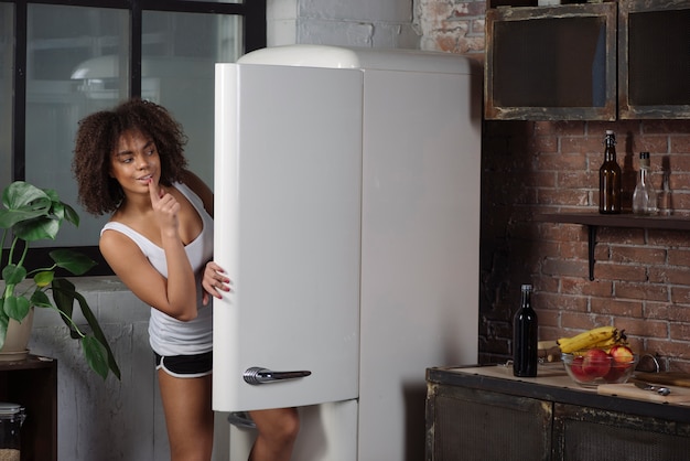 Kostenloses Foto frau in der küche, die kühlschrank untersucht