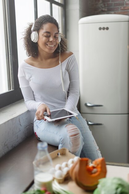 Frau in der Küche mit Tablette