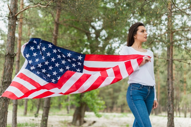 Frau in der Natur, die amerikanische Flagge hält